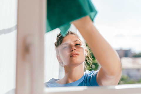 Young Woman Cleaning a Window