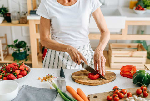 Woman cutting peppers in kitchen