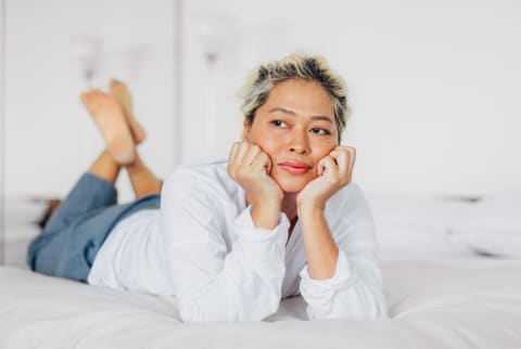 Woman in her 40s relaxing on her bed