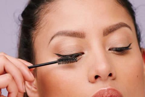 Woman Applying Mascara to Eyelashes