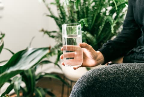 Woman Holding a Water Glass while Intermittent Fasting