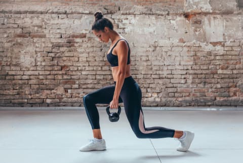 Woman Doing Lunges with Kettlebell Weights