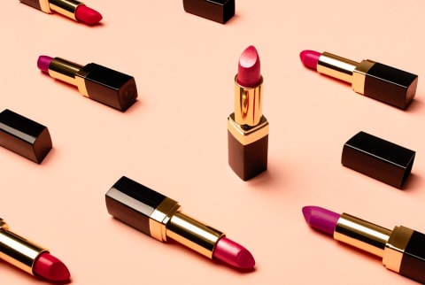 Variety of Red Lipsticks on a Peach Background