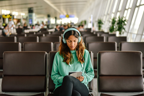 Woman Waiting in Airport Listening to Music Woman Waiting in Airport Listening to Music