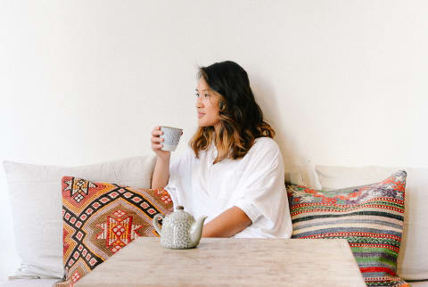 Woman Sitting at a Table Drinking Tea