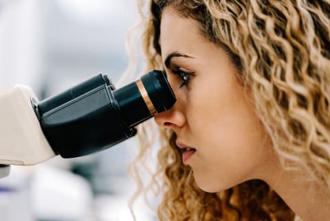 Woman Looking through Mircroscope