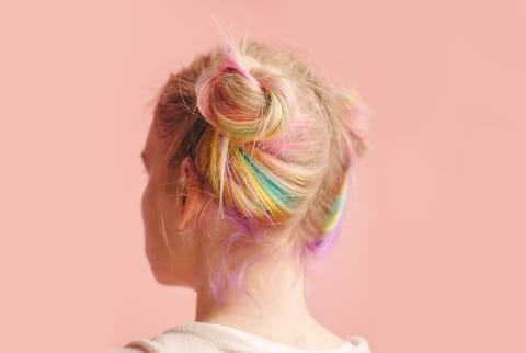 Woman with colorful hair on pink background