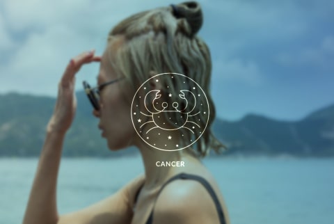 woman on the beach with cancer season symbol