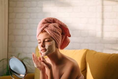 Woman applying post shower skin care