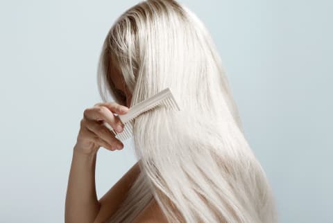 Woman Combing Long Blond Hair