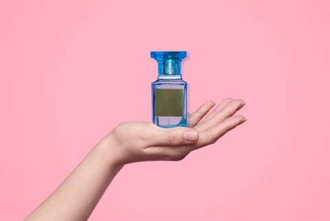 Crop hand presenting perfume stock photo
