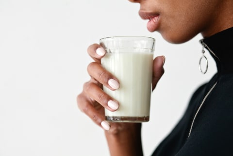 woman holding a glass of hemp milk