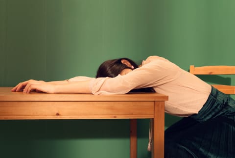 Tired Woman Sleeping On A Table