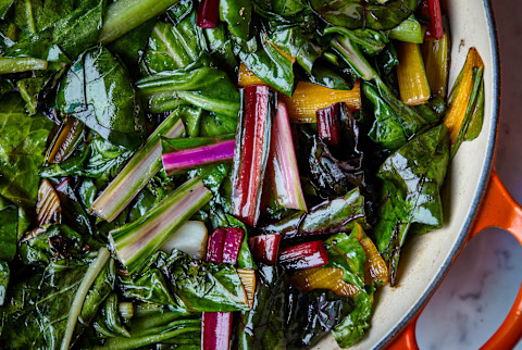 Close up of sautéed green veggies like rainbow Swiss chard and spinach in Dutch oven Close up of sautéed green veggies like rainbow Swiss chard and spinach in Dutch oven