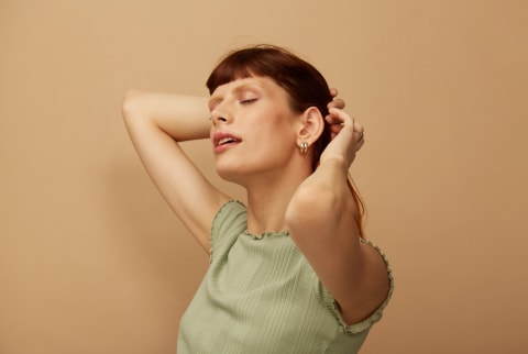 woman with hands massaging scalp