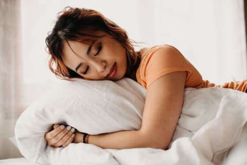Asian woman sleeping and well rested in bed