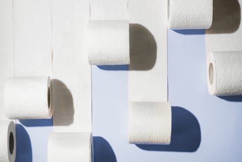 Abstract minimal shot of toilet paper rolls on blue-purple seamless