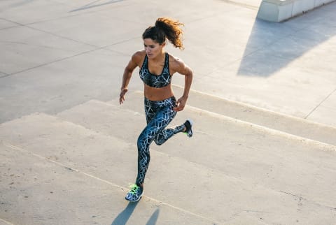 woman sprinting up a flight of stairs