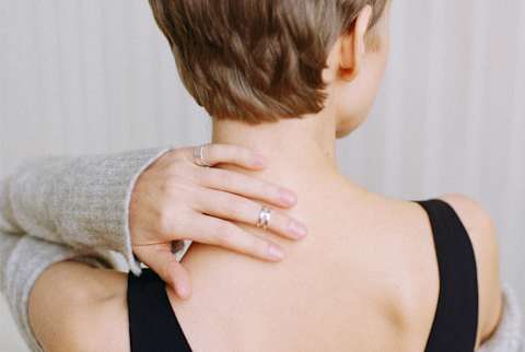 Woman Rubbing Back of Neck Woman Rubbing Back of Neck
