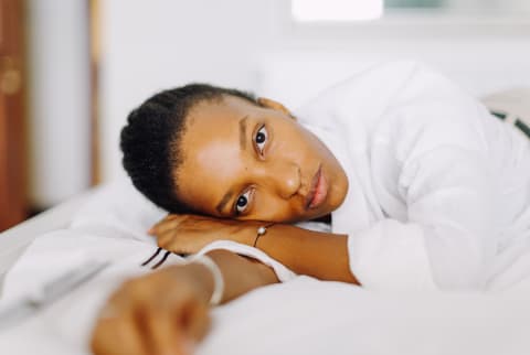 Woman Lying On Her Bed Looking Distressed