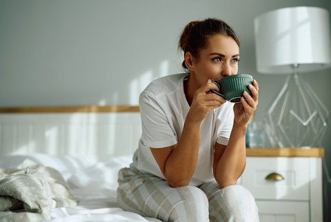 woman drinking tea in bed woman drinking tea in bed