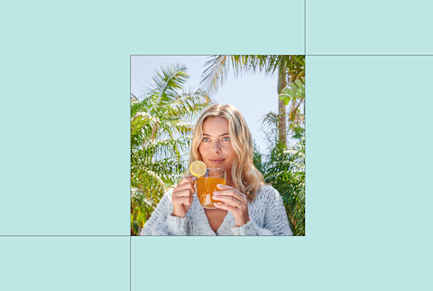 zuma turmeric tonic in glass with woman drinking