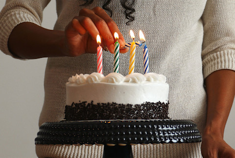 woman lighting birthday candles