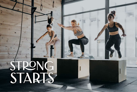 Women doing box jumps at a gym Women doing box jumps at a gym