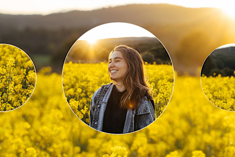 Woman grinning in field of yellow flowers as the sun sets