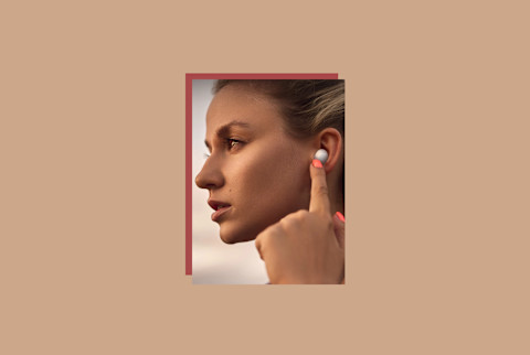 samsung galaxy buds2 review image of women with headphones in ears pressing button samsung galaxy buds2 review image of women with headphones in ears pressing button