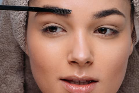 woman brushing eyebrows