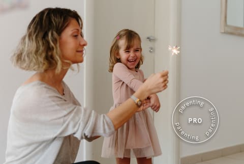 Mother and daughter lighting a sparkler for New Years - Pro Parenting