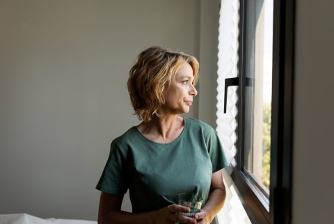 Portrait of pensive senior woman looking towards window at home