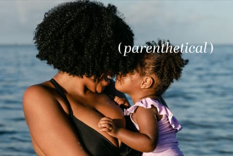 Mother holding daughter near the ocean