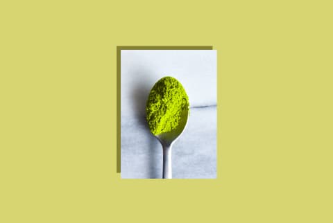 photo of a spoon with matcha powder on green background