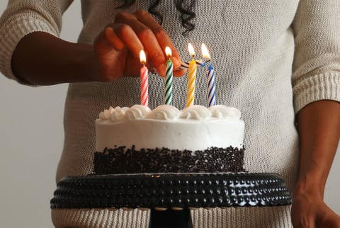 woman lighting birthday candles