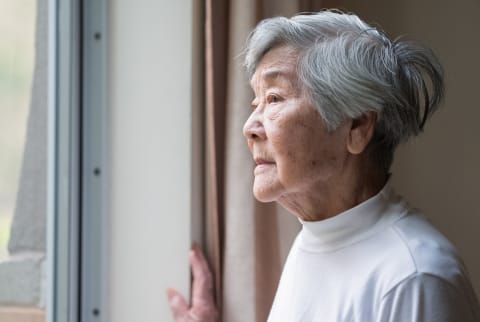 Chinese senior woman looking outside