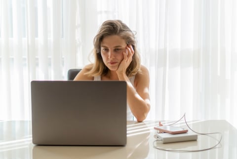 Women sitting desk looking at laptop