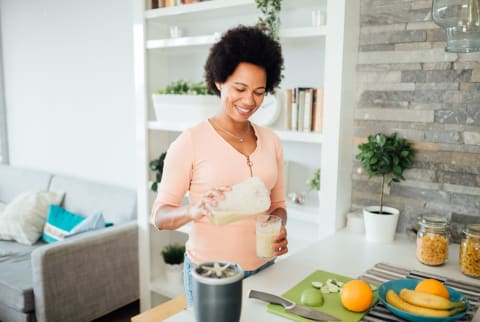 Happy African American woman preparing a nutritional breakfast at home