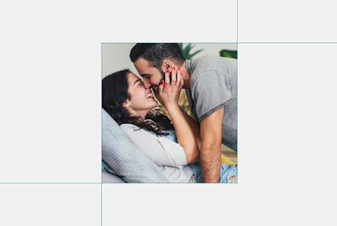 photo of man and woman kissing on grey background