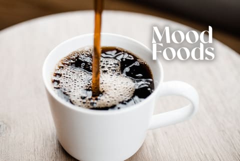 Coffee being poured into a white ceramic mug