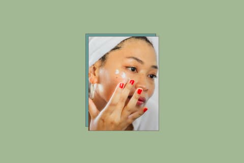 Women applying eye cream on freshly washed skin on green background