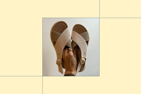 photo of editor's hand holding up the vivaia adaptall sport sandals on yellow background photo of editor's hand holding up the vivaia adaptall sport sandals on yellow background