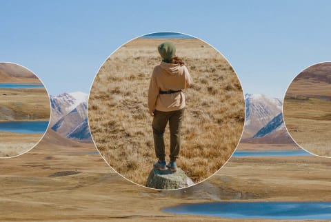 Female hiker stand outdoors in stunning mountain nature landscape enjoying her adventure trip