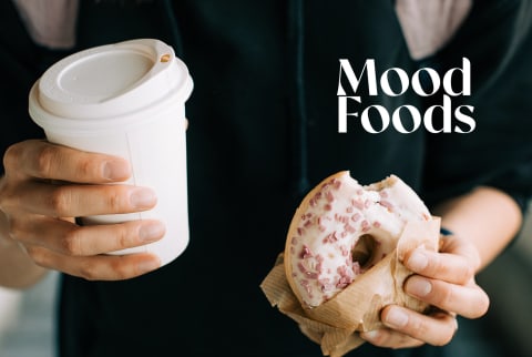 woman holding donut and coffee