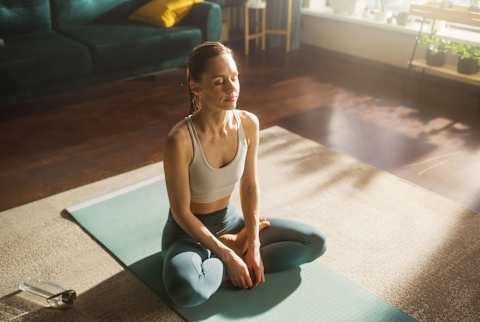 Woman sitting cross-legged on the floor Woman sitting cross-legged on the floor