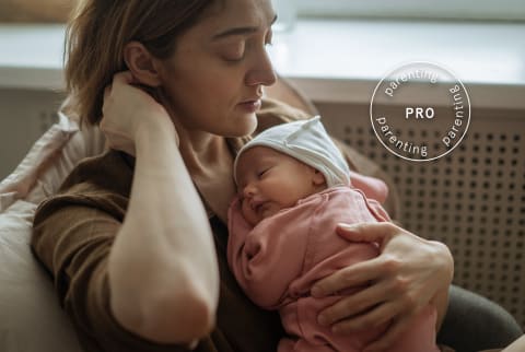 Mother holding newborn baby with Pro Parenting lockup/stamp