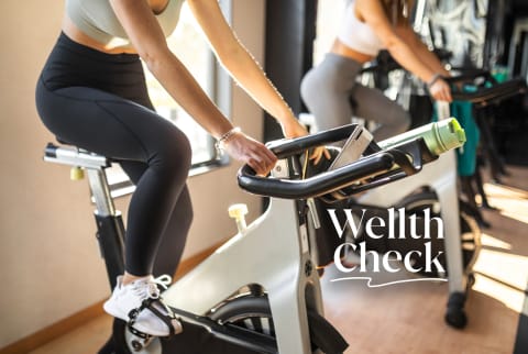 Woman on an exercise bike in a gym - Wellth Check