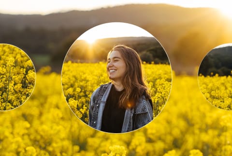 Woman grinning in field of yellow flowers as the sun sets