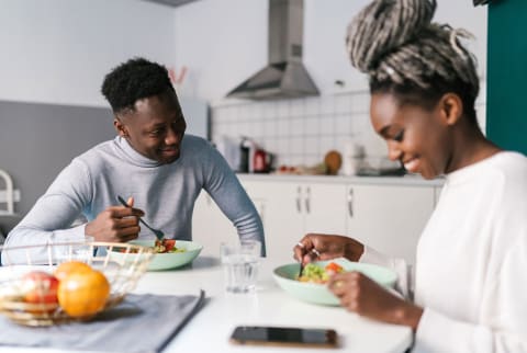 Couple sitting at kitchen table eating